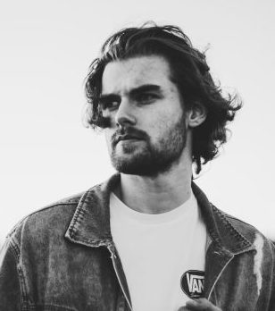 Artistic black and white portrait of a man in denim with expressive pose.
